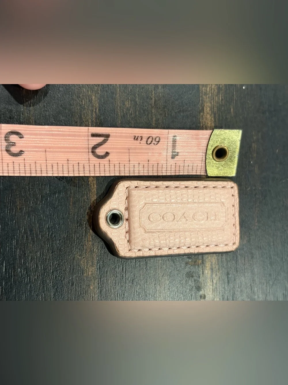 Light pink snakeskin embossed Coach hangtag